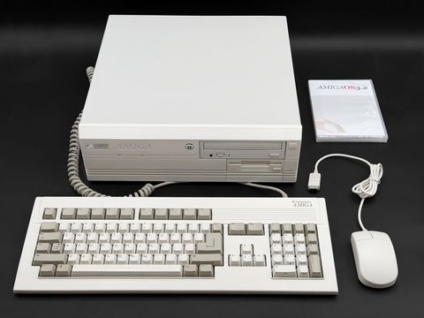 Amiga 4000 desktop case with its Amiga keyboard and mouse and an AmigaOS 3.2 disc case, arranged and shot straight on