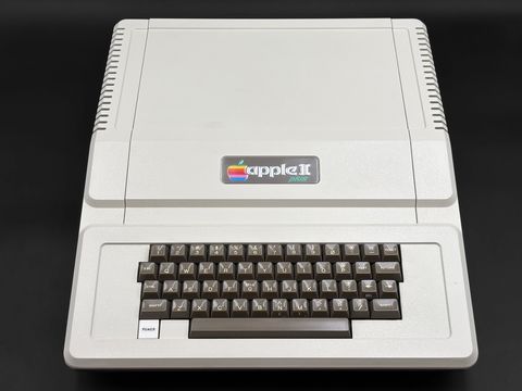 Straight-on front view of the cream Apple II Plus case with the rainbow 'apple II plus' badge above the built-in brown-keycap keyboard, alone (no monitor, drives or manuals)
