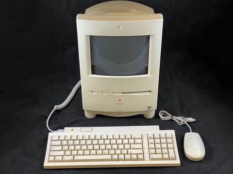 Macintosh Color Classic from the front, screen off, with an Apple keyboard and a mouse laid out in front
